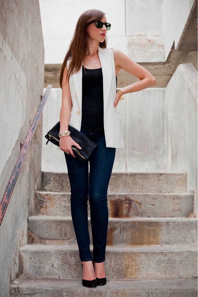 Style in white vest, jeans, black top with black clutch and heels